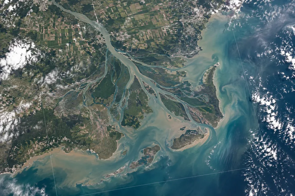 Vista orbital de um delta de rio, áreas agrícolas e ecossistemas costeiros.